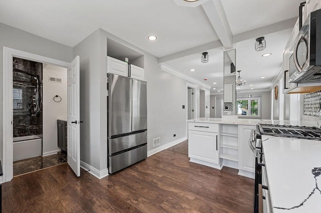 kitchen featuring visible vents, dark wood-style floors, a peninsula, stainless steel appliances, and white cabinetry