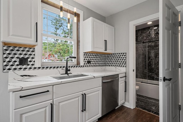 kitchen featuring dark wood-type flooring, white cabinets, a sink, light stone countertops, and dishwasher