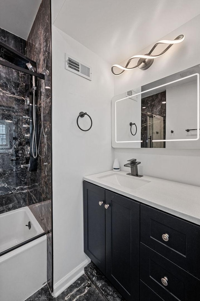 full bath featuring marble finish floor, visible vents, enclosed tub / shower combo, vanity, and baseboards