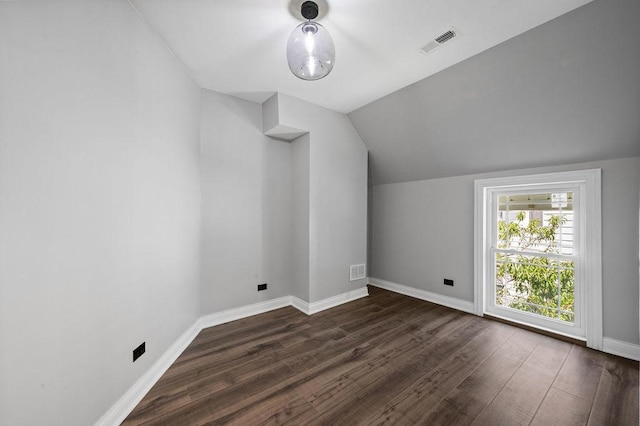 bonus room featuring lofted ceiling, dark wood finished floors, visible vents, and baseboards