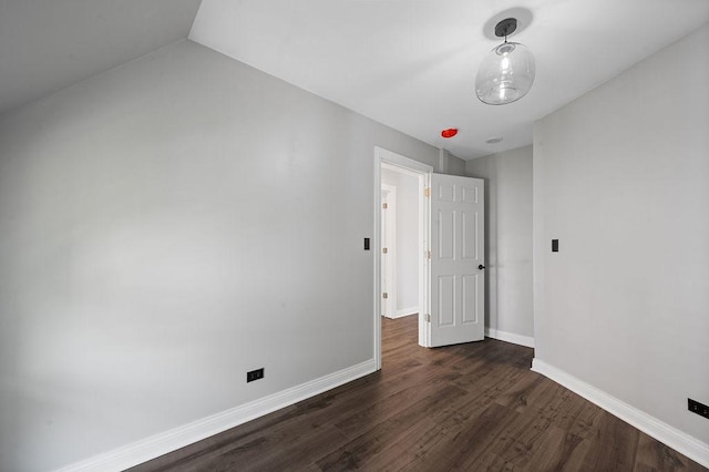 unfurnished bedroom featuring baseboards and dark wood finished floors