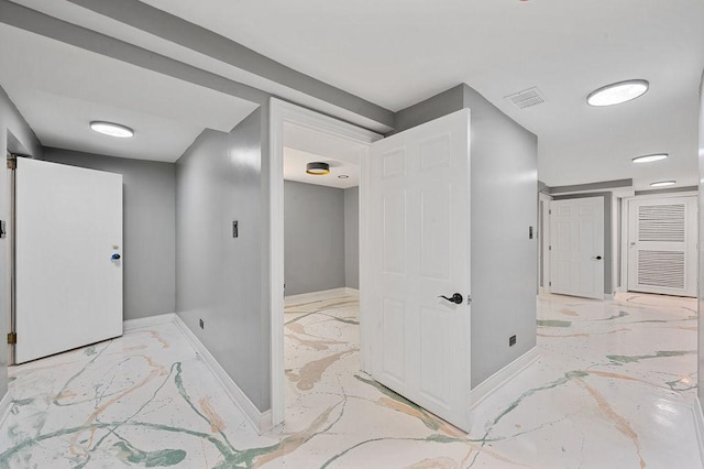 hallway featuring marble finish floor, visible vents, and baseboards