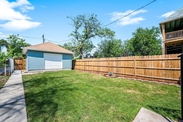 view of yard featuring driveway, a fenced backyard, a garage, and an outdoor structure