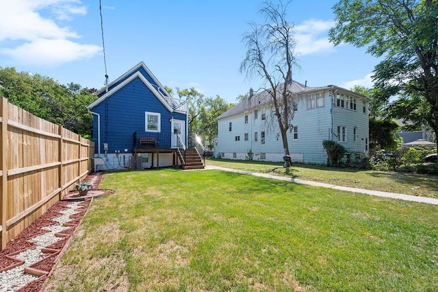 back of property featuring a lawn and fence