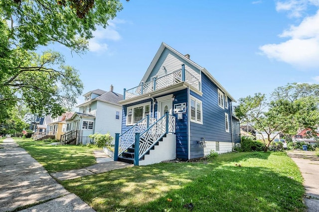 view of front of property with a balcony and a front lawn