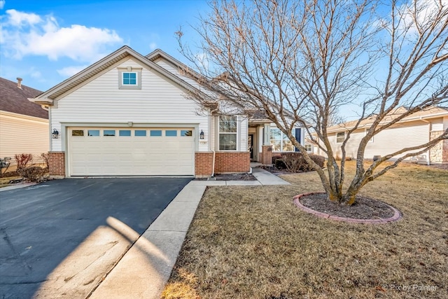 view of front facade featuring brick siding, a front lawn, an attached garage, and aphalt driveway