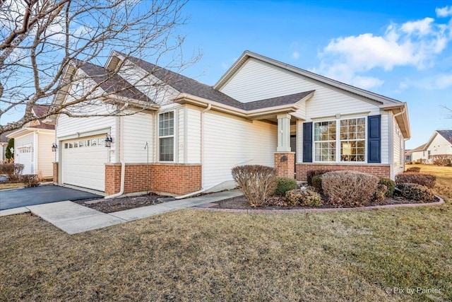 view of front of house featuring driveway, an attached garage, a front lawn, and brick siding