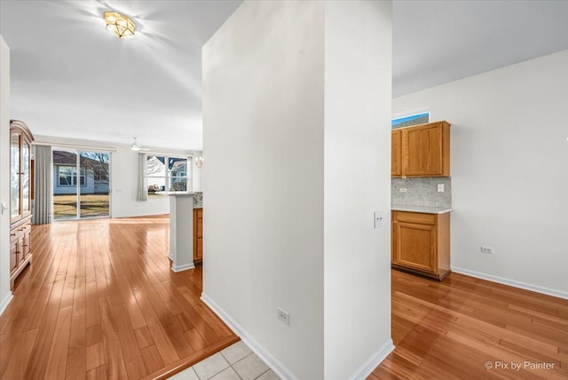 hallway featuring baseboards and light wood-style floors