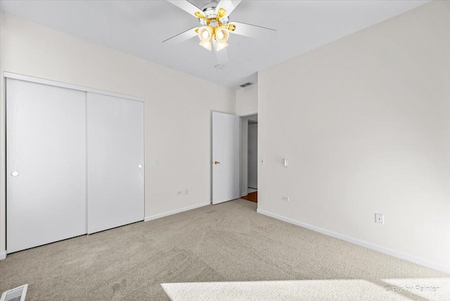 unfurnished bedroom with baseboards, carpet, visible vents, and a closet