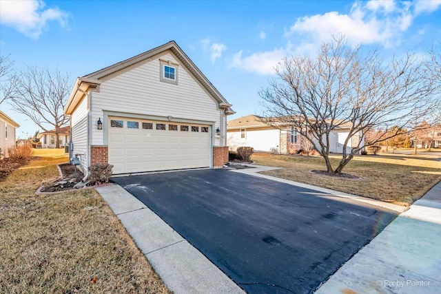 view of property exterior featuring aphalt driveway, brick siding, and a garage