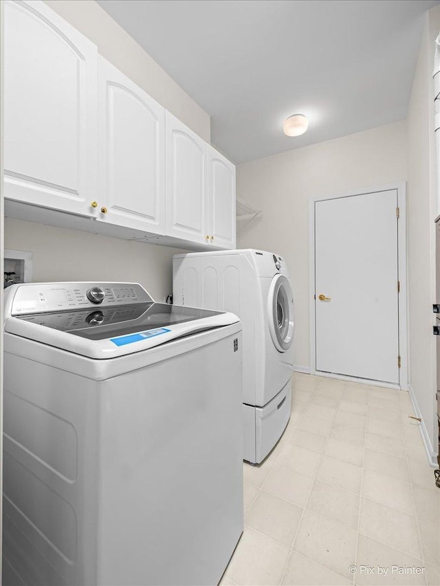 washroom with washing machine and dryer and cabinet space