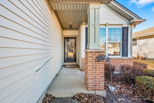 view of exterior entry featuring brick siding