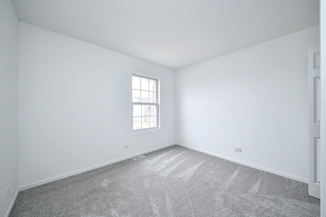 empty room featuring baseboards, visible vents, and carpet flooring