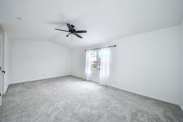 spare room with lofted ceiling, ceiling fan, baseboards, and carpet flooring