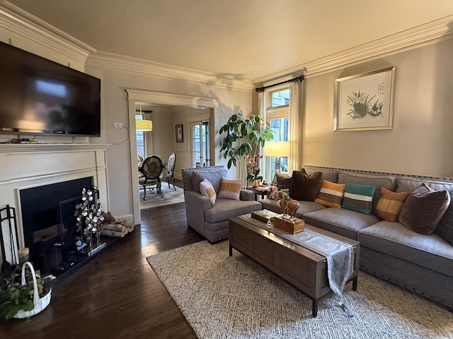 living room with ornamental molding, a fireplace, and wood finished floors