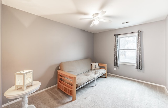 living area featuring baseboards, visible vents, ceiling fan, and carpet flooring