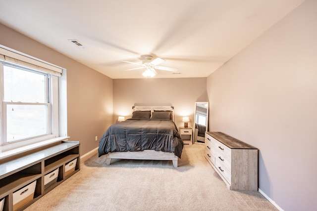 bedroom with visible vents, multiple windows, ceiling fan, and light carpet