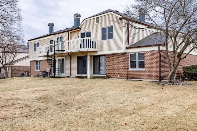 rear view of property with brick siding, a chimney, and a lawn