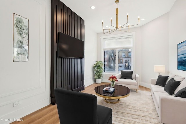 living area featuring a chandelier, light wood finished floors, baseboards, and recessed lighting