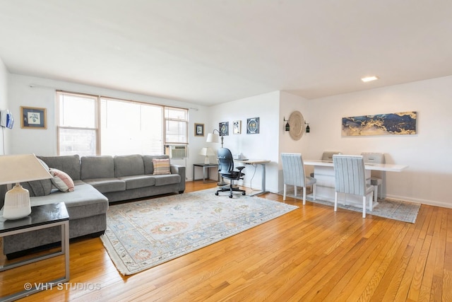 living area featuring hardwood / wood-style floors, cooling unit, and baseboards