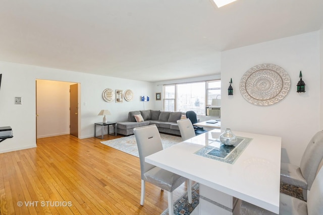 dining space featuring light wood-style flooring and baseboards