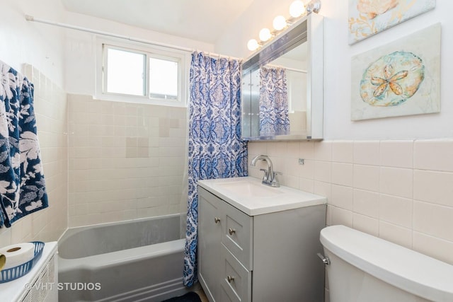 full bathroom with vanity, toilet, tile walls, and shower / tub combo