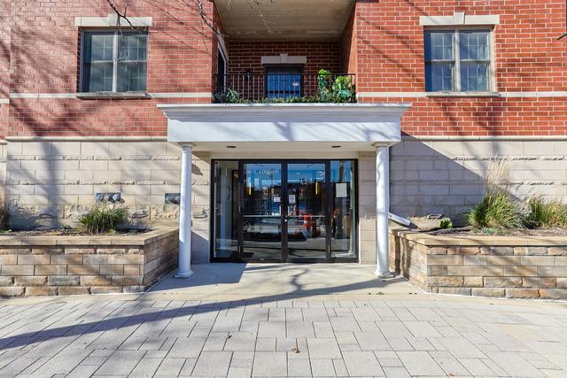 property entrance with brick siding, french doors, and a balcony