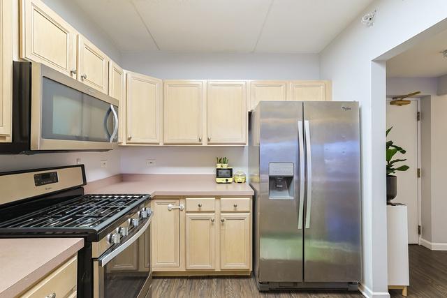 kitchen with stainless steel appliances, baseboards, wood finished floors, and light countertops