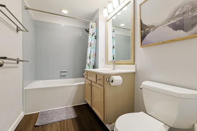 bathroom with vanity, wood finished floors, recessed lighting, shower / tub combo, and toilet