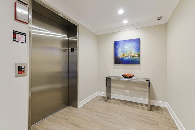 hallway featuring recessed lighting, elevator, light wood-style floors, and baseboards