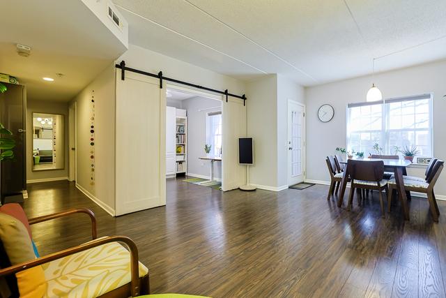 dining space featuring visible vents, a healthy amount of sunlight, a barn door, and wood finished floors