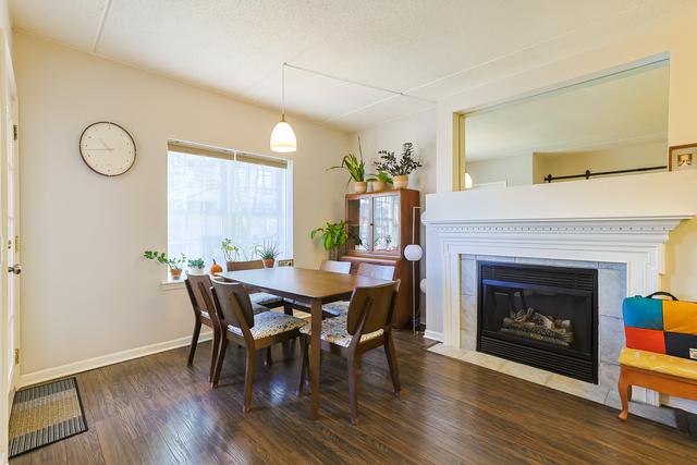 dining area featuring baseboards, wood finished floors, and a tiled fireplace