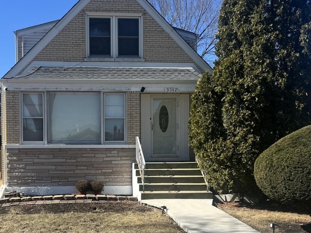 view of front of property featuring entry steps and roof with shingles