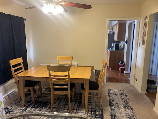 dining area with a ceiling fan, baseboards, and carpet flooring