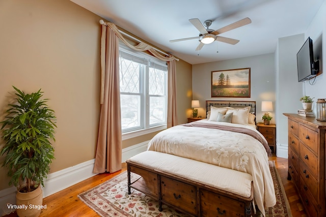 bedroom featuring a ceiling fan, baseboards, and wood finished floors