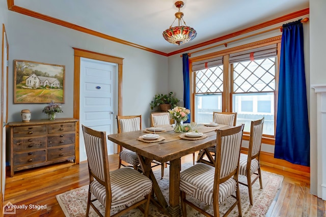 dining room with ornamental molding and light wood finished floors