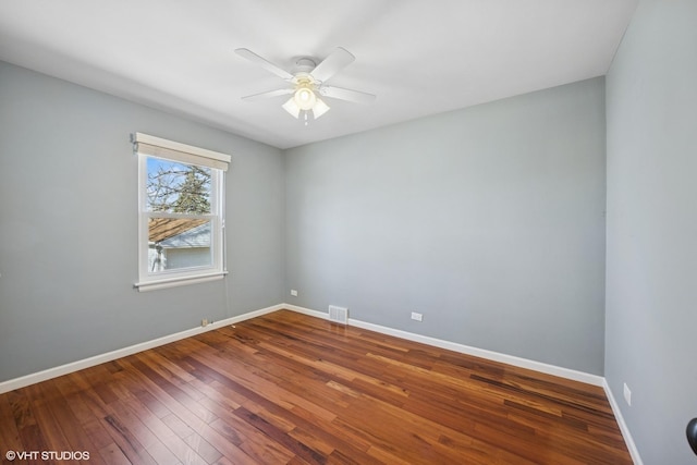 empty room with hardwood / wood-style flooring, baseboards, visible vents, and ceiling fan