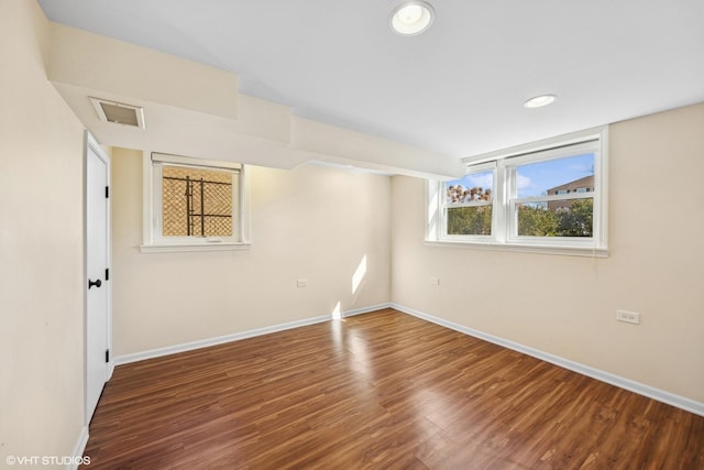 spare room with baseboards, visible vents, wood finished floors, and recessed lighting