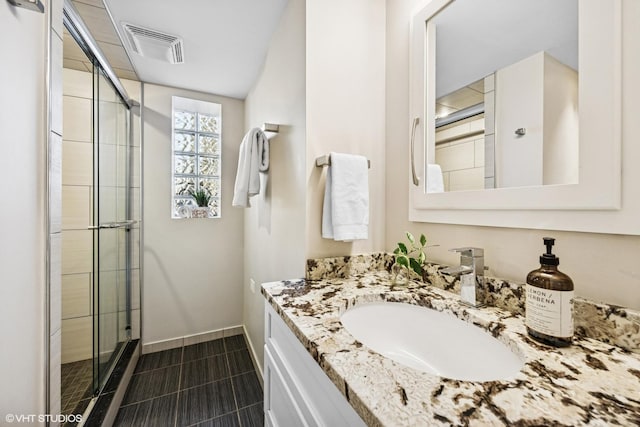 bathroom with a stall shower, tile patterned flooring, visible vents, and vanity