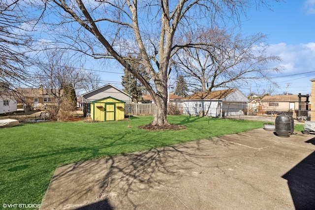 view of yard with a residential view, fence, an outdoor structure, and a shed