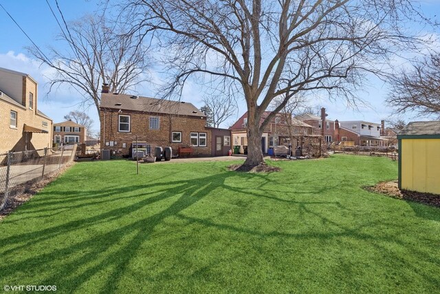 view of yard with central AC unit and fence