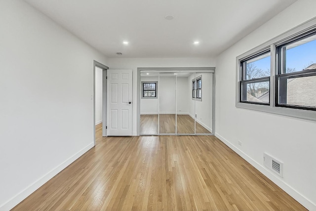 unfurnished bedroom with visible vents, baseboards, light wood-type flooring, recessed lighting, and a closet