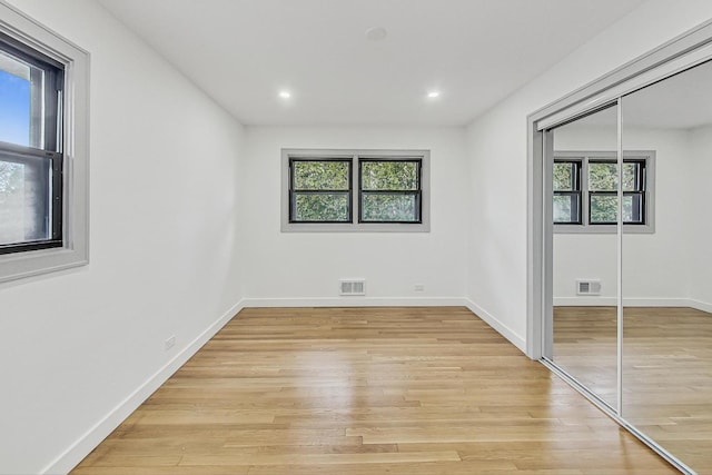 unfurnished bedroom with a closet, visible vents, and light wood-type flooring