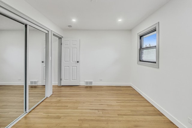 unfurnished bedroom featuring visible vents, baseboards, and light wood finished floors