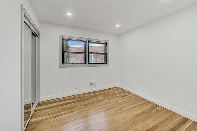 unfurnished bedroom with visible vents, light wood-style flooring, recessed lighting, a closet, and baseboards