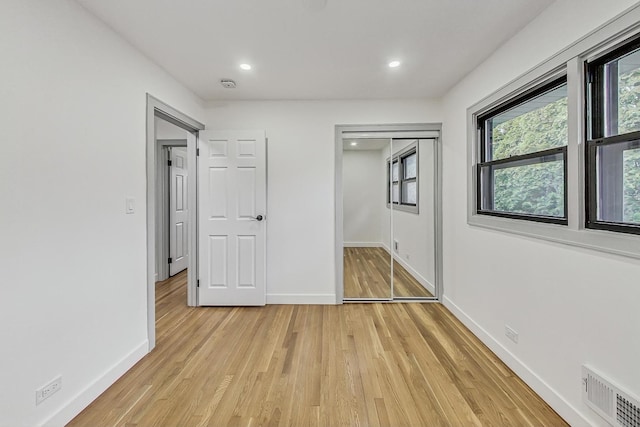 unfurnished bedroom featuring recessed lighting, visible vents, light wood-style flooring, and baseboards