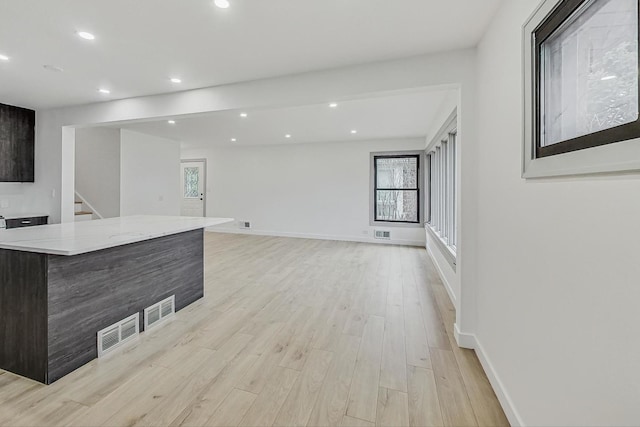 living area featuring visible vents, recessed lighting, baseboards, and light wood-style floors