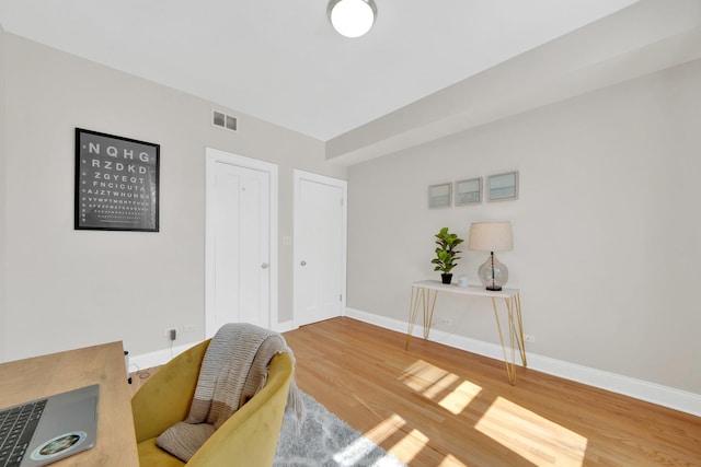 office featuring visible vents, baseboards, and wood finished floors