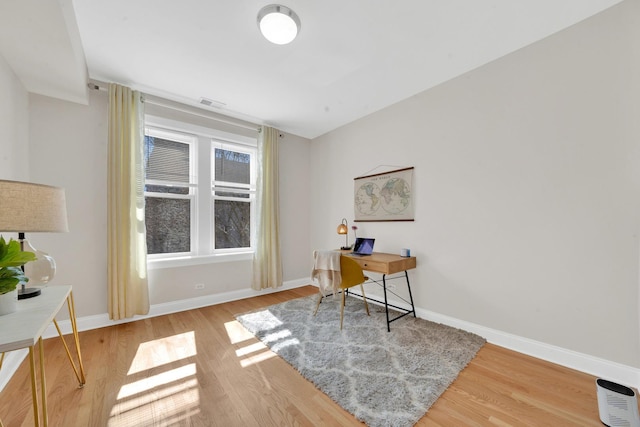 home office featuring visible vents, baseboards, and wood finished floors