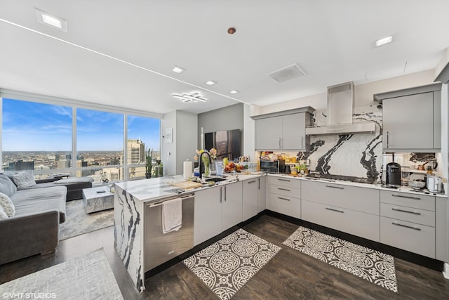 kitchen featuring open floor plan, gray cabinets, a peninsula, island range hood, and gas stovetop